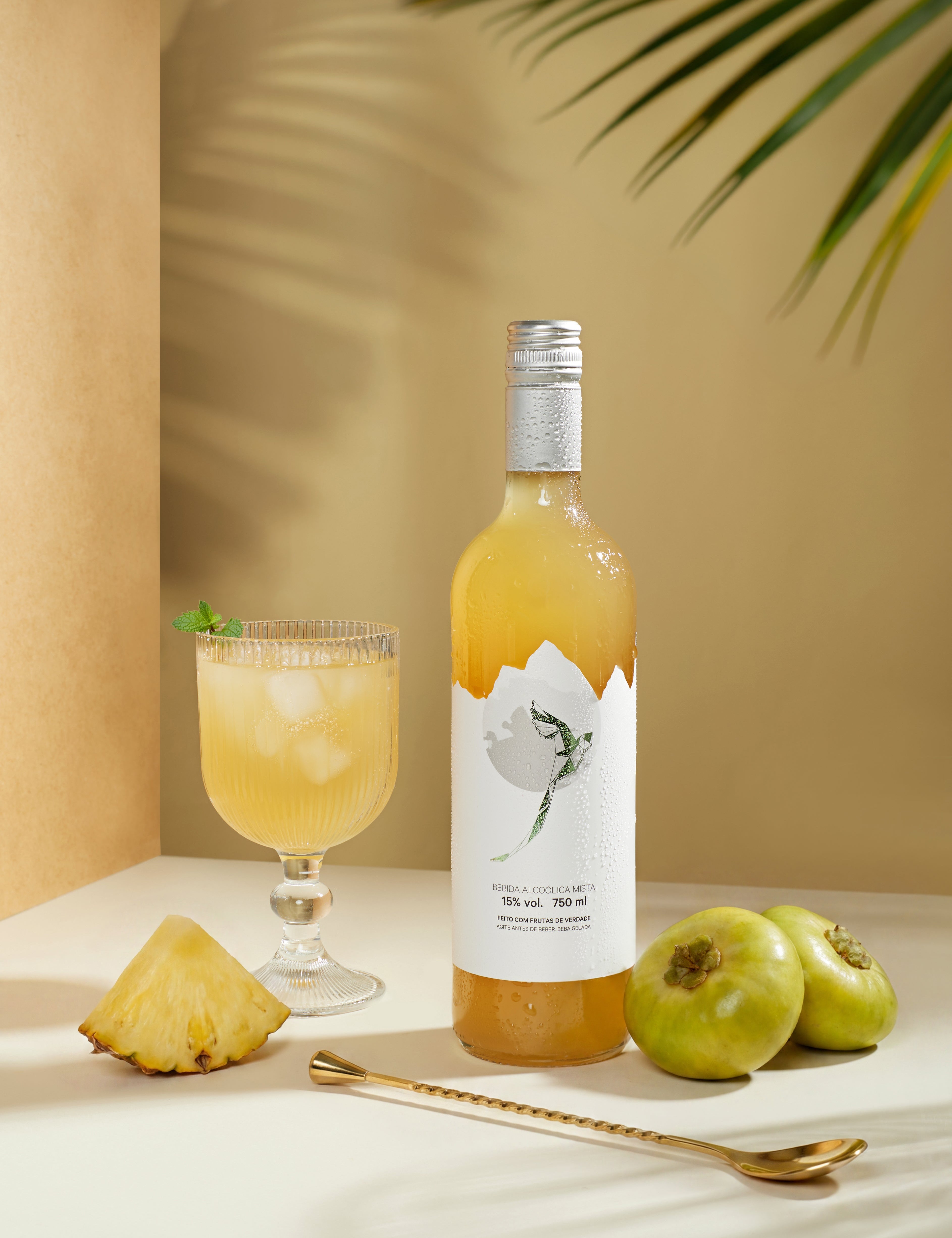 Quetzalli Cambuci e Abacaxi garrafa de 750 ml com frutas in natura de cambuci e abacaxi com uma taça de vinho com gelo 